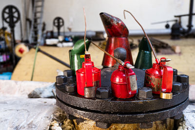 Close-up of oil cans on metal in factory