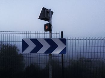 Road sign against sky