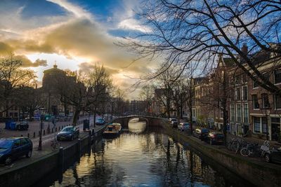 Bridge over canal in city against sky