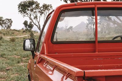 Abandoned car on field against sky