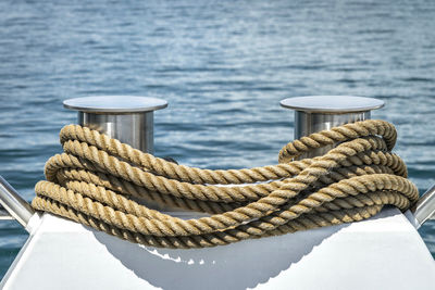 Close-up of rope tied to boat moored at harbor