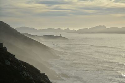 Scenic view of sea and mountains against sky