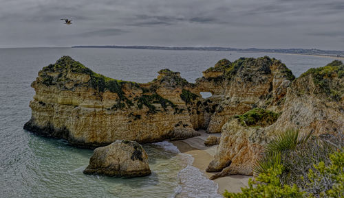 Rocks on sea shore against sky