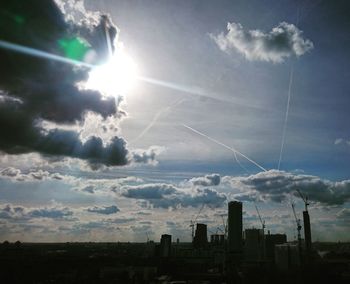 Silhouette cityscape against sky