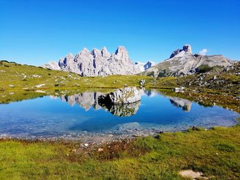 Scenic view of lake and mountains against blue sky