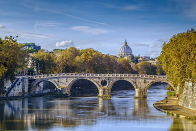 Arch bridge over river against sky