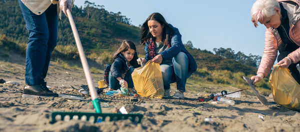 Family picking garbage at beach