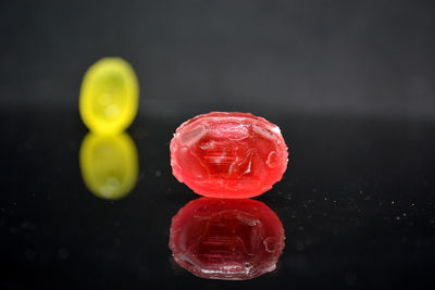 Close-up of multi colored glass on table against black background