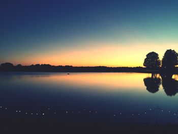 Scenic view of lake against clear sky during sunset