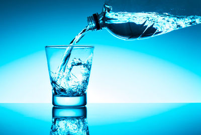 Close-up of glass of water against blue background