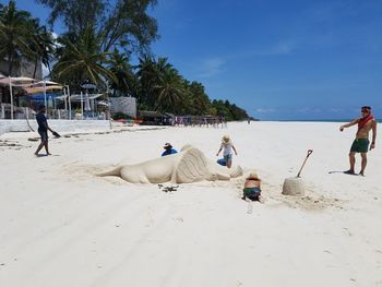 People at beach against sky