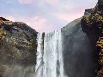 Scenic view of waterfall against sky