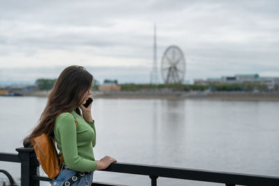 Rear view of young woman looking through window