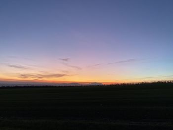 Scenic view of silhouette field against sky during sunset