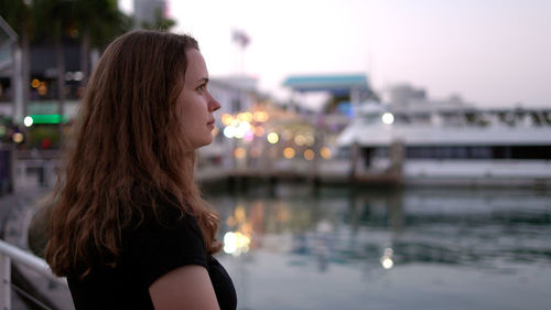 Side view of young woman looking at river