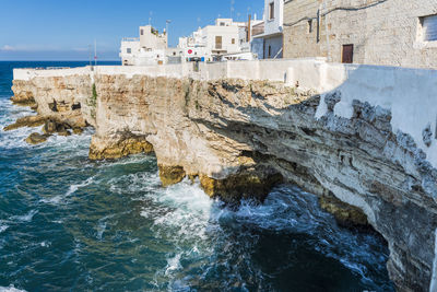 Rock formation by sea against sky