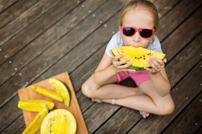 Portrait of young woman sitting on boardwalk