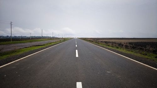 Country road against sky