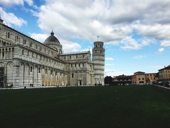 Buildings in city against cloudy sky