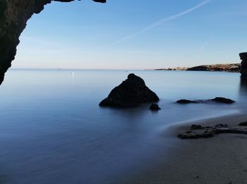 Scenic view of rocks in sea against sky