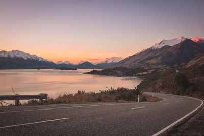 Road leading towards mountains at sunset