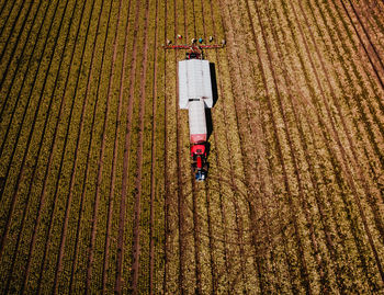 High angle view of tractor and farmers working on field