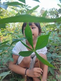 Portrait of woman holding leaves outdoors