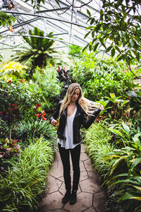 Woman standing by tree trunk