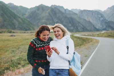 Smiling young woman looking away while standing on mountain