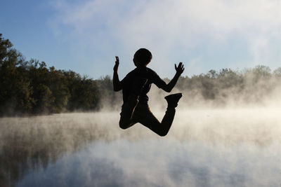 Full length of man jumping against sky