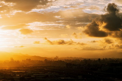 Aerial view of cityscape against sky during sunset