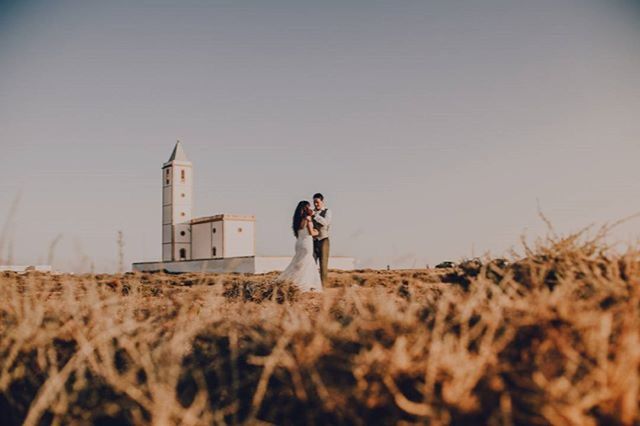 lifestyles, leisure activity, field, clear sky, rear view, casual clothing, standing, photography themes, young adult, copy space, grass, building exterior, full length, holding, architecture, landscape, men, built structure