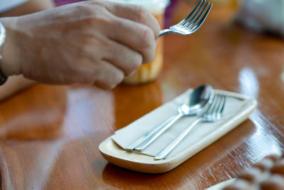 Close-up of hand holding ice cream on table