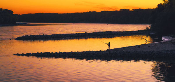 Scenic view of lake against orange sky