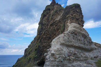 Low angle view of rock formation on sea against sky