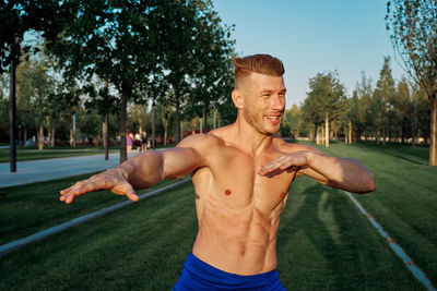 Portrait of shirtless man exercising in park