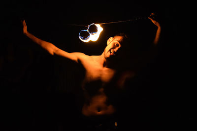 Portrait of fire performer against black background