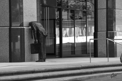 Man walking by window of building