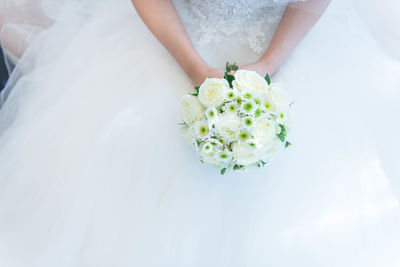 Low section of woman holding rose bouquet