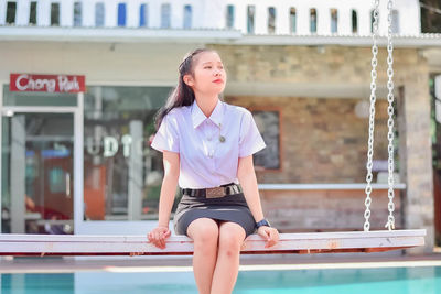 Portrait of young woman standing in swimming pool