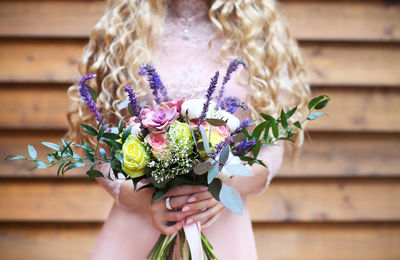 Midsection of woman holding flower bouquet