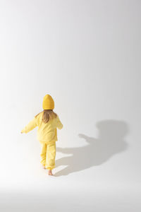 Rear view of woman standing against white background