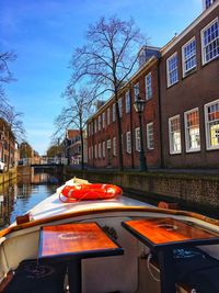 View of building by canal against sky