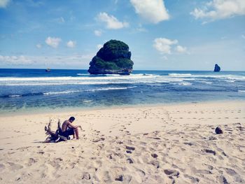 People at beach against sky