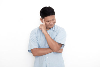 Young man standing against white background