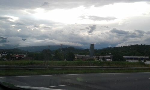 Scenic view of wet road against sky