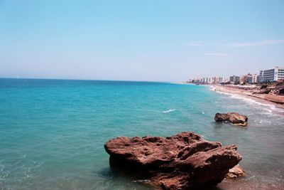 Rock formation on beach against sky