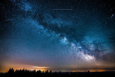 Scenic view of landscape against star field at night