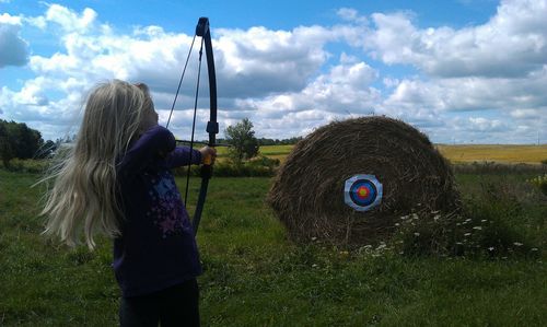 Girl aiming on bull-eye at farm