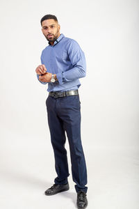 Portrait of man standing against white background